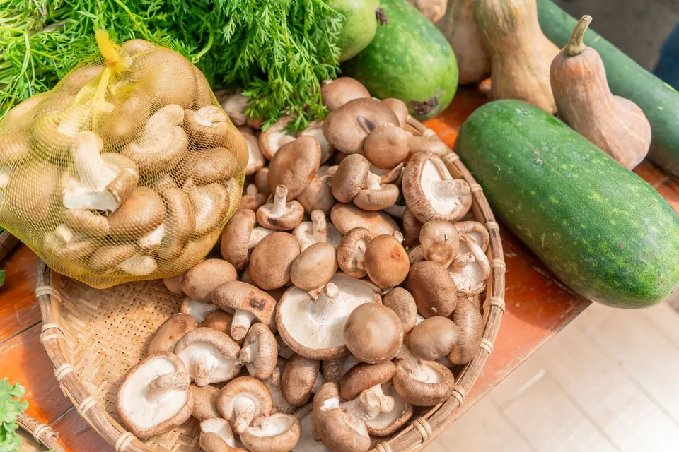 Frische Shiitake und Gemüse auf einem Holztisch
