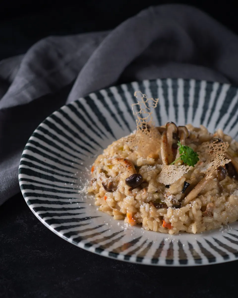 Pilzrisotto auf einem gestreiften Teller